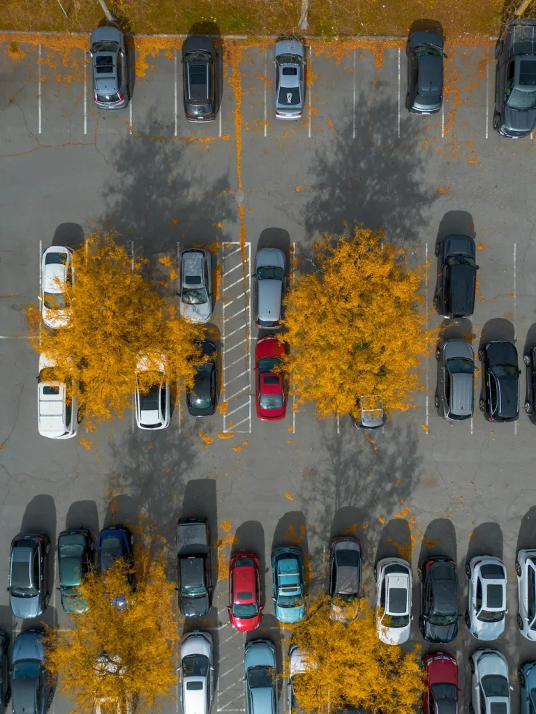 Vue de dessus d'un parking profitant de l'ombre d'arbres plantés entre les stationnements